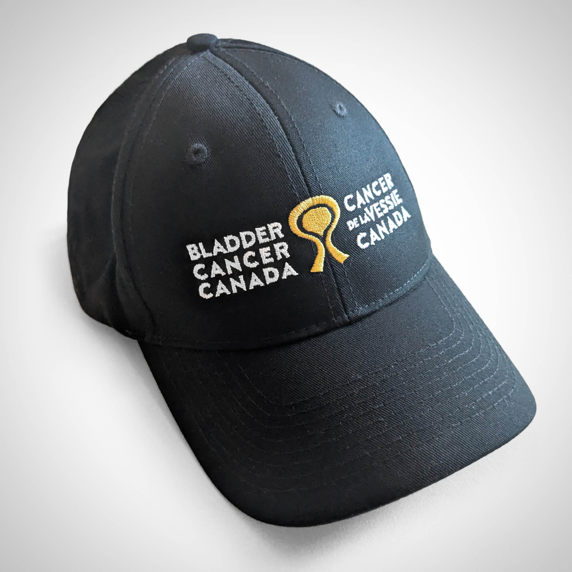 Black baseball cap with the Bladder Cancer Canada bilingual logo embroidered on the front.
